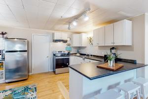 een keuken met witte kasten en een roestvrijstalen koelkast bij Maplewood Manor - Unit 2 in Colchester
