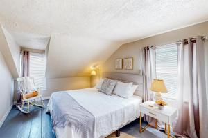 een slaapkamer met een bed en 2 ramen bij Maplewood Manor - Unit 2 in Colchester