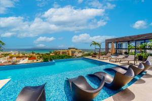 a pool with chairs and a view of the ocean at Perfect Place 302 in Playa del Carmen