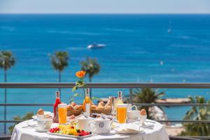- une table avec de la nourriture et une vue sur l'océan dans l'établissement Hôtel Barrière Le Majestic Cannes, à Cannes