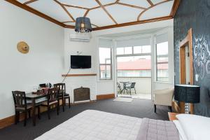 a bedroom with a bed and a table and a tv at AhiKaa Gisborne Motel in Gisborne