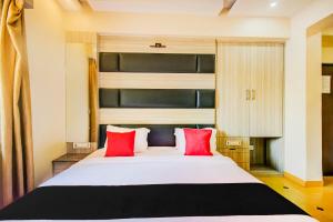 a bedroom with a large white bed with red pillows at Collection O 30965 Baga Residency in Baga