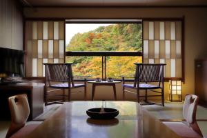 una stanza con tavolo e sedie e una grande finestra di Zao Onsen Omiya Ryokan a Zaō Onsen