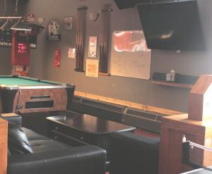 a ping pong table in a bar with a pool table at Esterhazy Motor Hotel in Esterhazy
