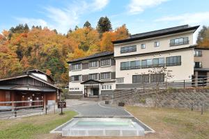 ein großes weißes Gebäude mit einem Weg dorthin in der Unterkunft Zao Onsen Omiya Ryokan in Zao Onsen