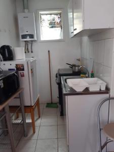 uma pequena cozinha com um lavatório e um frigorífico em Histórica y cómoda em Valparaíso