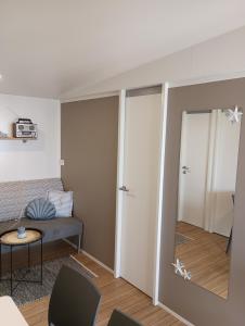 Sala de estar con cama y espejo en Lado Mobile Home Croatia, Camp Oaza Lučica, Drage, en Drage