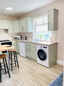 a kitchen with a washing machine and a table at Portmagee Village Apartments in Portmagee