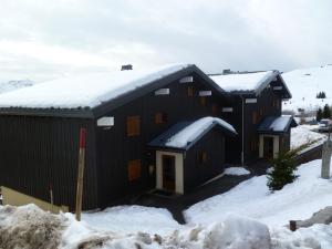 オトリュスにあるAppartement Les Saisies, 1 pièce, 4 personnes - FR-1-594-201の屋根に雪が積もった黒い家