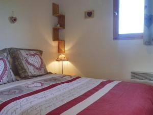 a bedroom with a bed with a red and white blanket at Appartement Crest-Voland, 3 pièces, 4 personnes - FR-1-595-75 in Crest-Voland