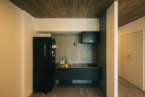 uma cozinha com um frigorífico preto e um lavatório em ambit - Vacation STAY 99416v em Kami Amakusa