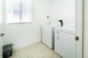 a white laundry room with a washer and dryer at 5 Bedrooms near Chinatown, DTLA, Art District in Los Angeles