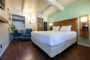 Emerald Bay Lodge في ساوث ليك تاهو: غرفة نوم بسرير كبير وكرسي ازرق