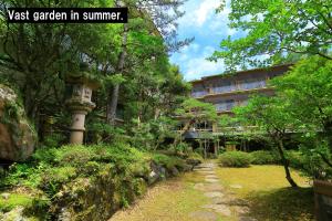 a garden with a building in the background at Manten no Tsujinoya in Komatsu