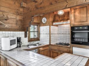 a kitchen with wooden cabinets and a counter top with a microwave at Chalet Confort 4 Chambres à Megève Rochebrune - Proche Téléphérique, Jardin, 2 Étoiles, Animaux OK - FR-1-453-233 in Megève +5 photos