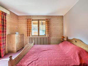 een slaapkamer met een groot houten bed met een rode sprei bij Appartement Megève, 3 pièces, 4 personnes - FR-1-453-253 in Megève