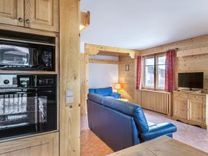 een woonkamer met een bank en een televisie in een hut bij Appartement Megève, 3 pièces, 4 personnes - FR-1-453-253 in Megève