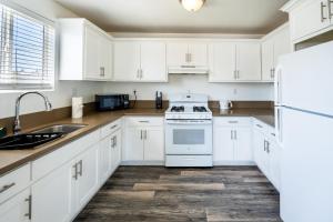 ロサンゼルスにあるModern Spacious 5 Bedrooms 3-Bath near Downtown LA with 2 Parkingの白いキャビネット、シンク、冷蔵庫付きのキッチンが備わります。 +22枚の写真