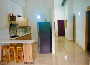- une cuisine équipée d'un réfrigérateur au milieu d'une pièce dans l'établissement El Paraiso Del Oasis, à Medellín