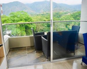d'un balcon avec des chaises et une vue sur les montagnes. dans l'établissement El Paraiso Del Oasis, à Medellín