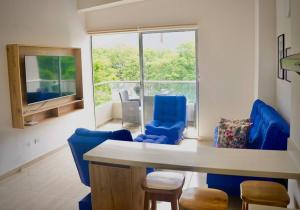 - un salon avec des chaises bleues et une table dans l'établissement El Paraiso Del Oasis, à Medellín