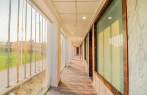 pusty korytarz w budynku z dużymi oknami w obiekcie Flagship Sitar Guest House w mieście Rudrapur