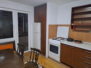 een keuken met een wit fornuis en een koelkast bij Dramski apartment in Skopje