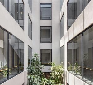 a facade of a building with windows and plants at Hotel Elements by Marquis in Mexico City