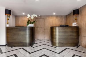 a lobby with two reception desks with a vase of flowers at Hotel Elements by Marquis in Mexico City