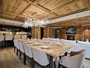 a dining room with a large wooden table and chairs at Chalet Airelles - Luxe et Confort au Pied des Pistes avec SPA et Services de Conciergerie - FR-1-613-52 in Méribel