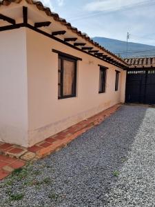 a white house with a black gate and a driveway at Casa Villa Ramos in Villa de Leyva