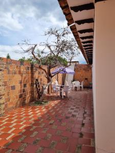 a patio with a tree and chairs and a wall at Casa Villa Ramos in Villa de Leyva