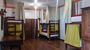 a room with three bunk beds and a desk at Terra Sagrada Cusco in Cusco