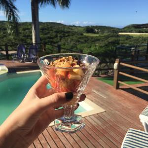 una persona sosteniendo un vaso con un postre en él en Pousada Mar'Tito Forno, en Búzios