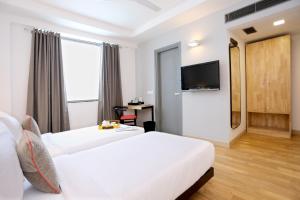 a hotel room with two beds and a flat screen tv at OYO Townhouse 012 Kaushambi Metro Ghaziabad in Ghaziabad