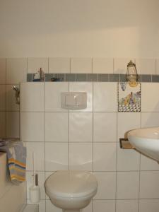 Baño blanco con aseo y lavamanos en Apartment Wittenberg en Lutherstadt Wittenberg