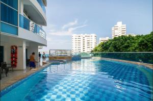 ein Pool neben einem Gebäude in der Unterkunft Apartamento lujoso a un minuto de la playa del laguito, la mejor playa de Cartagena de Indias in Cartagena de Indias