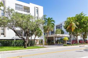 a street in front of a building with palm trees at Sunny Isles vacation condo. in Miami Beach