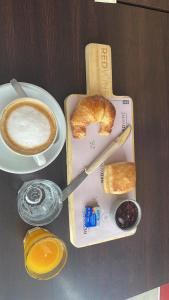 a table with a cup of coffee and a plate of bread at Urban Suites Oliva in Oliva