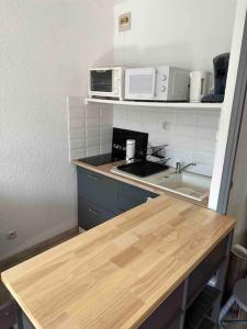 a kitchen with a counter top and a sink at Studio COSY à deux pas de la PLAGE ! in Gruissan +7 photos
