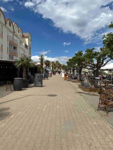 a street with benches and trees in a city at Studio COSY à deux pas de la PLAGE ! in Gruissan