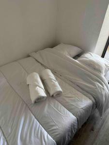 a white bed with two pillows on top of it at Studio COSY à deux pas de la PLAGE ! in Gruissan