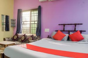 - une chambre avec un grand lit et un canapé dans l'établissement OYO Aradhya Regency, à Konârak