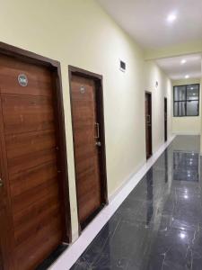 pasillo con 2 puertas de madera y suelo de baldosa en OYO Hotel Pravin Executive, en Gangāpur