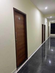 pasillo con puerta de madera en un edificio en OYO Hotel Pravin Executive, en Gangāpur