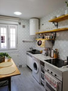 a kitchen with a stove and a washing machine at Piso Completo cerca de estación Bus, Tren y Ferrys in Santander