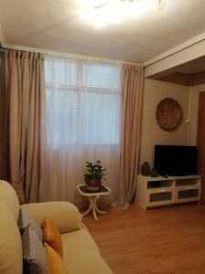 a living room with a couch and a window at Piso Completo cerca de estación Bus, Tren y Ferrys in Santander