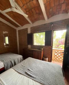 a bedroom with two beds and a window in it at Hosteria Chata Adults Only in Lo de Marcos