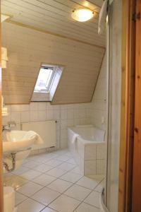 a bathroom with a sink and a tub and a toilet at Hotel Goldener Karpfen in Aschaffenburg