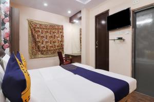 a hotel room with a bed and a tv at OYO Hotel 74966 Shree Amardeep Hotel in Hyderabad